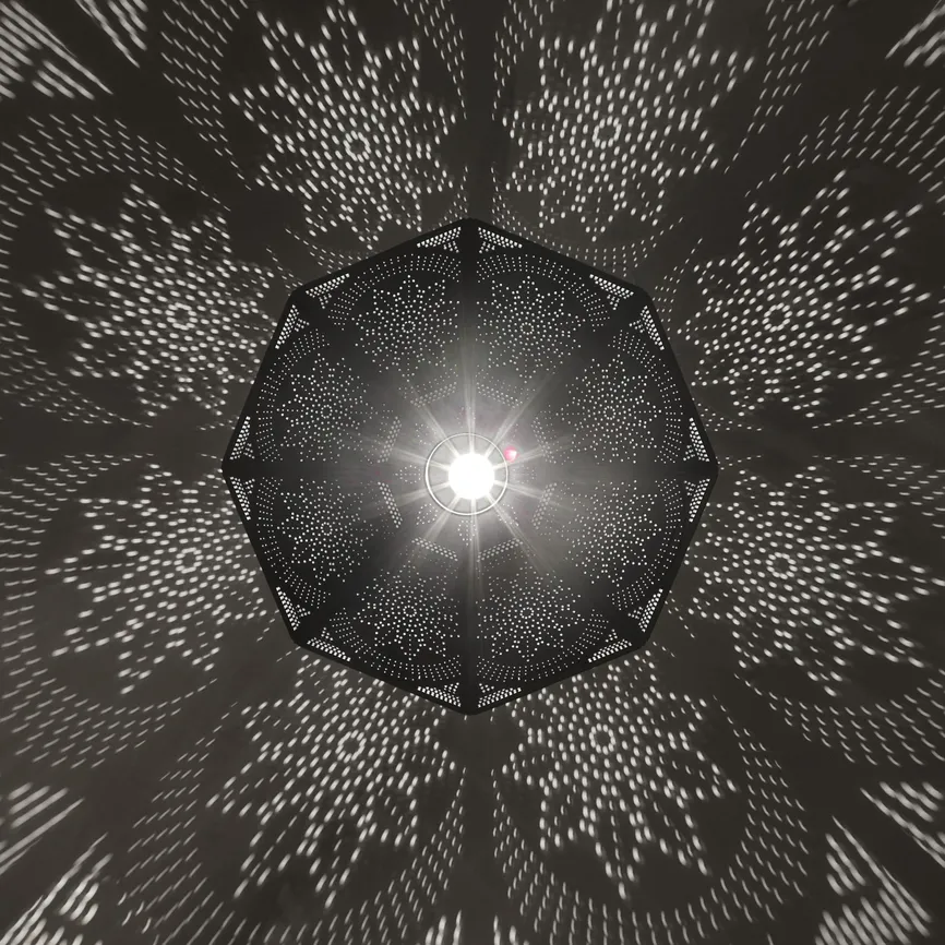 Decorative pendant light casting a starburst pattern at Célon Bar & Lounge
