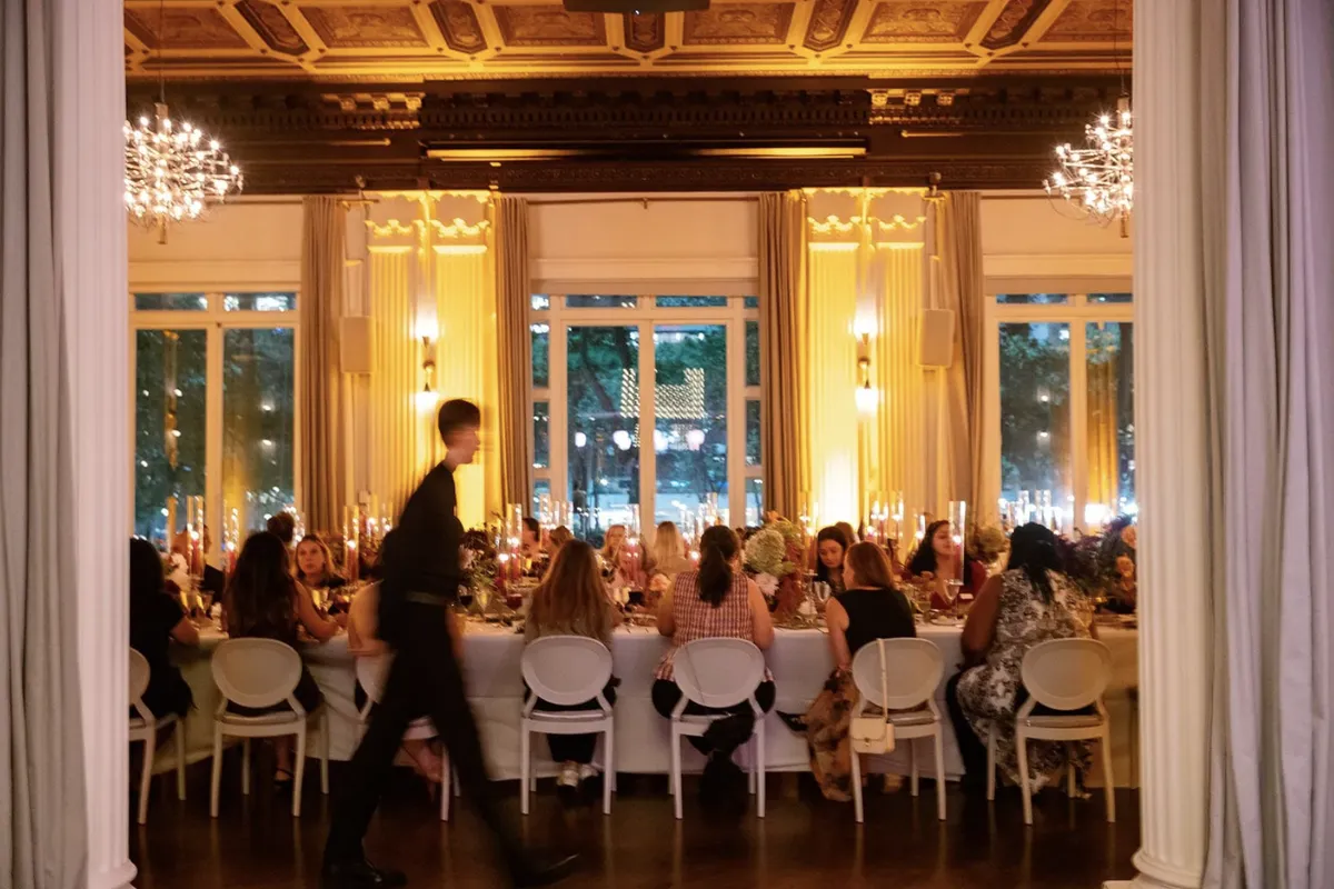 Long banquet table set for a formal dinner under chandeliers