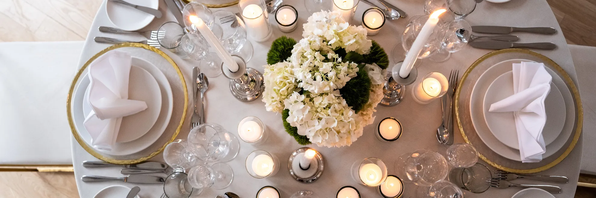 Overhead view of a round table set for a formal event with candles and floral centerpiece